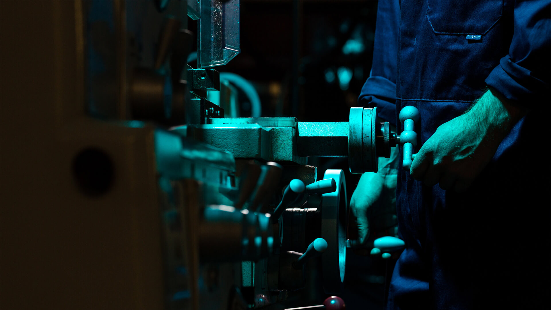 A person turning a hand crank on a machine.