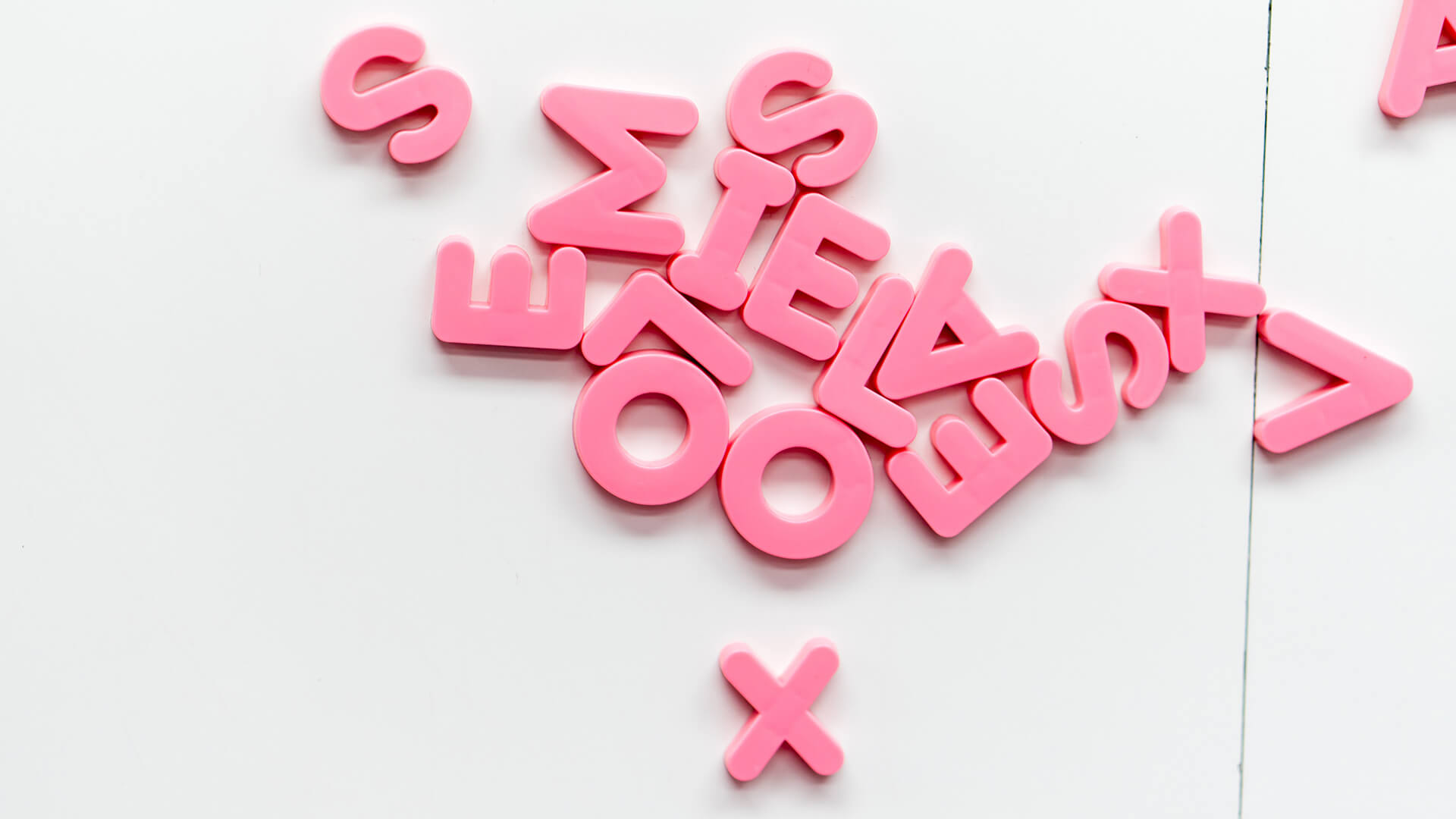 A variety of pink letter fridge magnets.