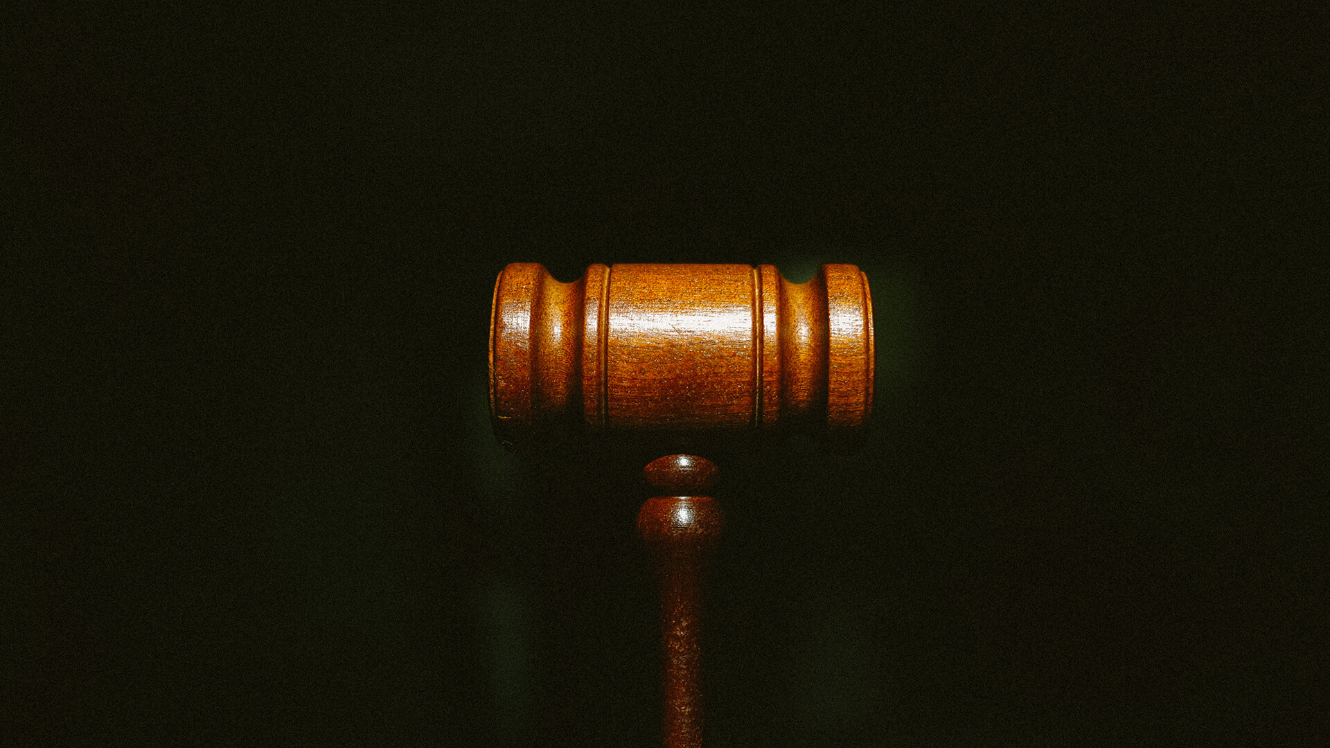 A Judges gavel on a black background.