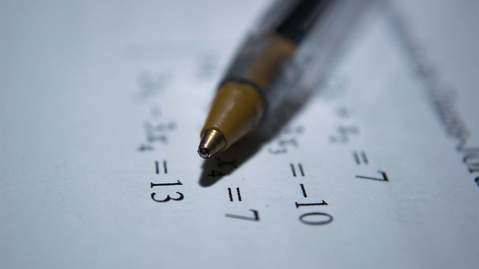 A woman writing math sums on a whiteboard.