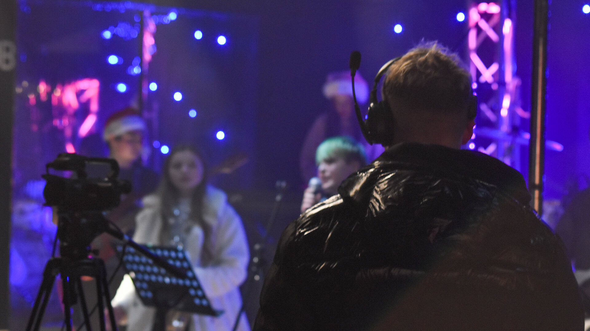 A man recording a band on stage.