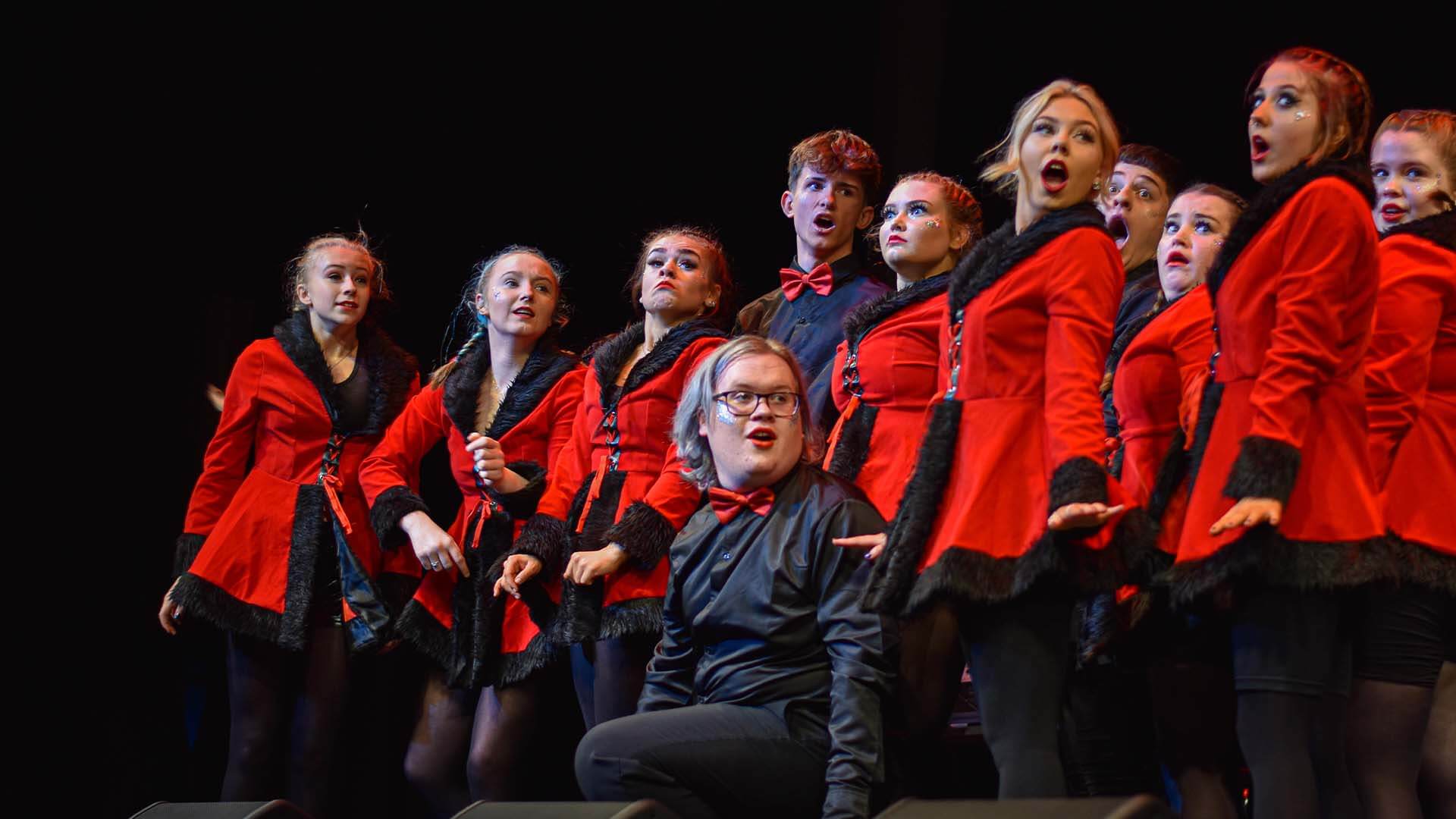 Various students performing a dance routine on a stage.