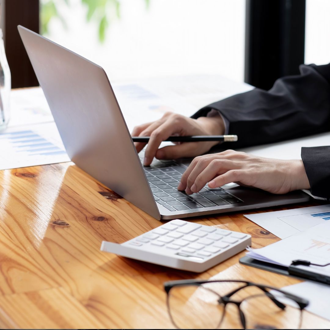 Person in suit typing on computer