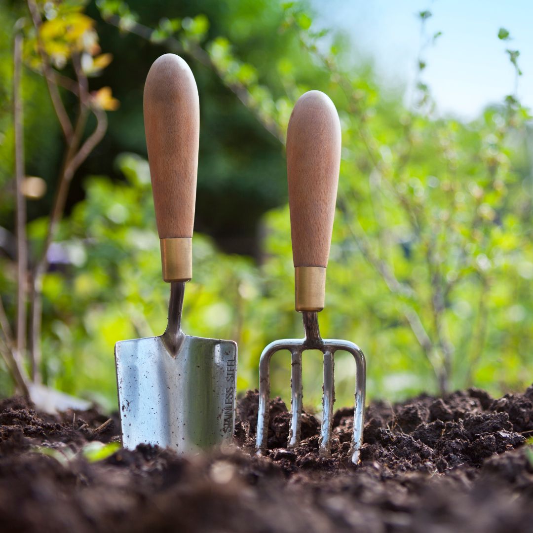 trowel and pitchfork in mud.