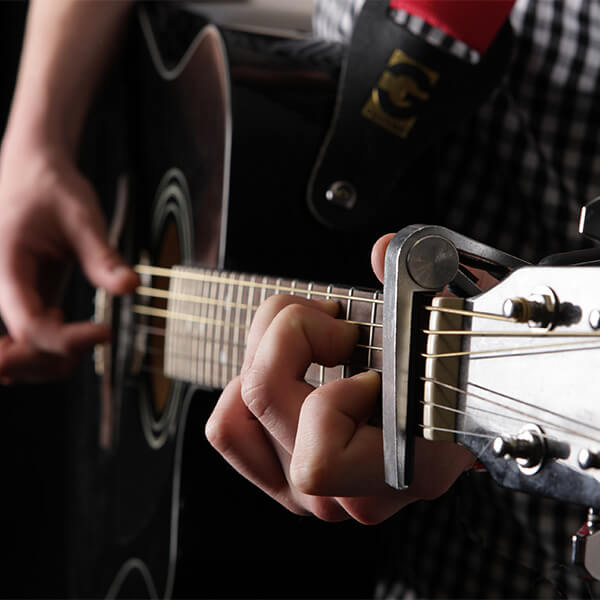 Two hands playing the guitar.