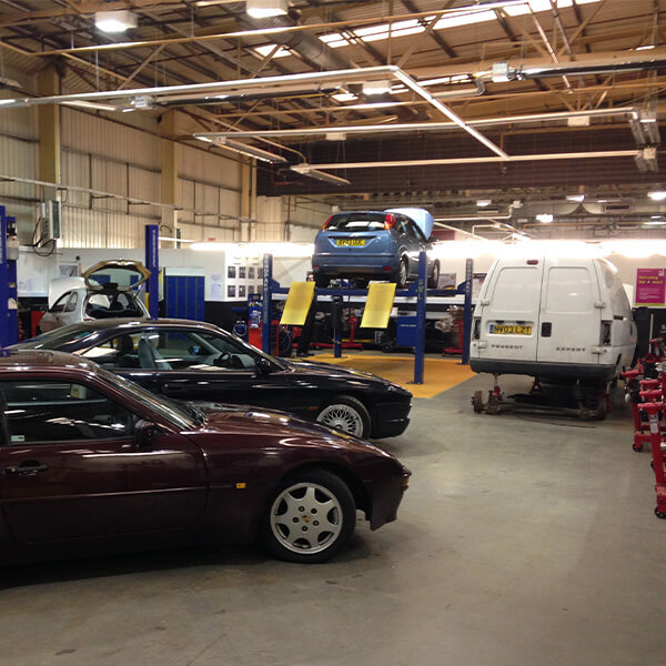 A garage with five cars in it.