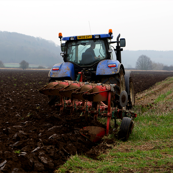 A tractor ploughing a muddy field