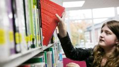 Girl taking a book from a shelve