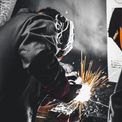 Man wearing welding mask welding and creating sparks