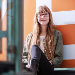 Female student, wearing glasses, smiling at the camera