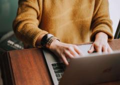 Close-up of someone typing on a laptop