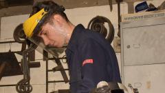 Engineer Callum Fishwick, wearing a protective mask, working in workshop