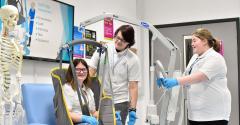 Three Care students in the EDC care room, one operating a winch, one sat in the winch