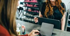 Close up of a customer credit card transaction while women uses till system