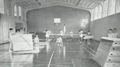 A black and white photo of the Easington College sports hall with men doing gymnastics