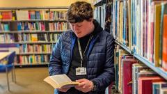 Evan Carroll reading a book in the EDC library