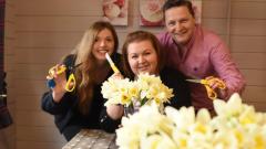 A group of three florists posing with flowers and scissors