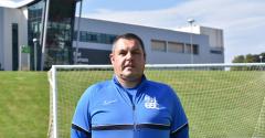 Ian Raine stood in front of goal and East Durham College building