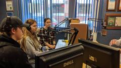 Three students, wearing headphones, doing radio takeover at Radio Hartlepool