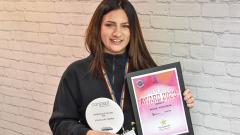 Rayna Kovacheva holding her Concept Hair awards against white background