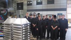 A group of East Durham College student pose next to metallic fabrication panels