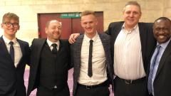 Five men in suits posing at TWI Awards Ceremony