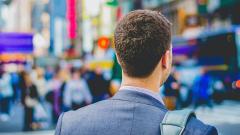 The back of a man's head stood in the blurred busy street scene