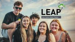 A group of five young people smiling at the camera, with the LEAP logo top right. LEAP stands for: Learn, Explore, Achieve, Progress