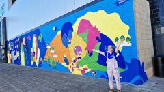 County Durham artist Hazel Oakes stood next to the new 14m wide mural she painted at East Durham College