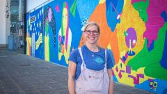 County Durham artist Hazel Oakes stood next to the new 14m wide mural she painted at East Durham College