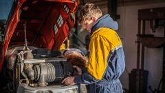 Engineering student working on a tractor's engine