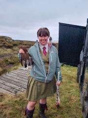 Female student smiling and holding a pheasant