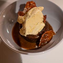 Sticky toffee pudding with ice cream and brandy snap biscuits in a bowl