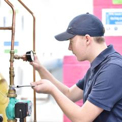 Person tightening bolts on pipes