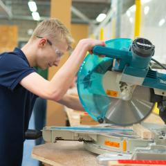 Joinery student cutting wood