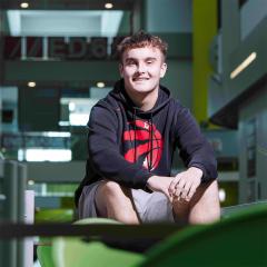 Student sitting on table in Peterlee campus atrium